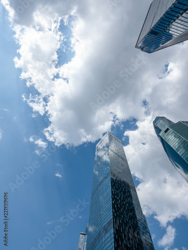 Modern glass skyscrapers with reflective facades rising against a clear blue sky in an urban setting