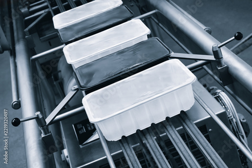 Metal conveyor belts move plastic containers used for food packaging. Mechanisms smoothly transport them along production lines.