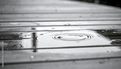 Rain droplets on wooden deck surface.