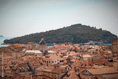 Fotografie Terracotta rooftops of Dubrovnik old town with green Lokrum island in the Adriat