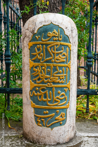 Ancient stone pillar bears golden Arabic script