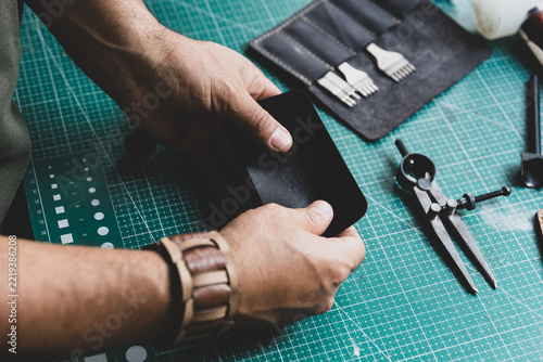 Leather artisan checking the softness and quality of a piece of leather with his hands.