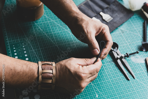 Leather artisan checking the softness and quality of a piece of leather with his hands.