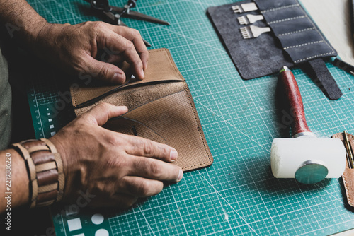 Leather artisan checking the softness and quality of a piece of leather with his hands.