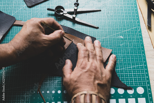 Artisan Hands Marking Leather with Ruler in Workshop