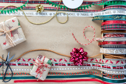 Holiday ribbons and decorations on brown paper with copy space in the middle.