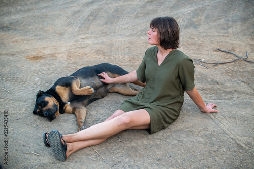 Woman seen sitting on ground with dog
