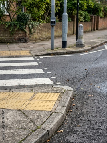 Urban Pedestrian Crossing with Tactile Paving and Zebra Stripes on Asphalt Road, City Street Infrastructure Scene, Safety Crosswalk Design, Accessible Sidewalk Curb, Traffic Control Environment