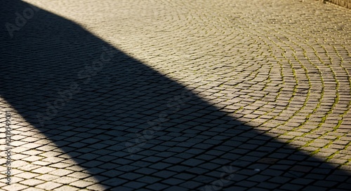 Sunlight and Shadow on Cobblestone Pavement.