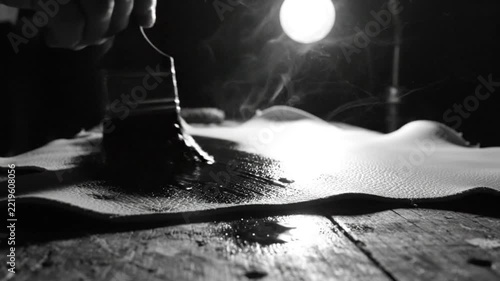 Artisan Applying Dye to Leather with Brush in Moody Lighting with Steam Rising