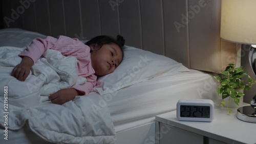 tired preschool child girl having trouble sleeping in a bed late at night, insomnia concept

