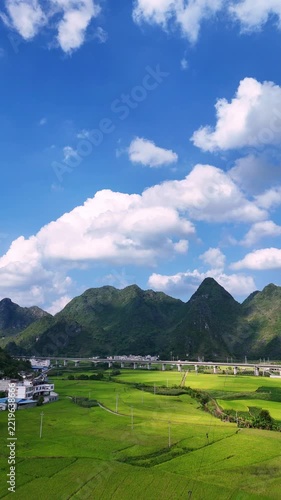 Vertical Video: Aerial view of a rural village and terraced fields under soft evening light.