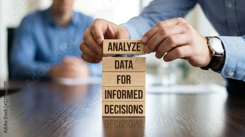 Analyze data for informed decisions concept with hands and wooden blocks
