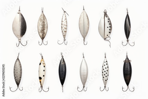 Vintage fishing lures creating a retro collection of angling equipment. Featuring antique metal spoons and weighted artificial baits with hooks arranged on a white background