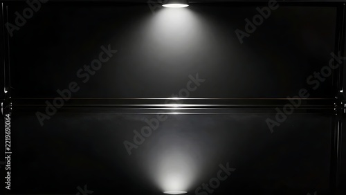 Spotlight illuminates black floor.