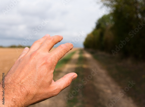 Main tendue chemin campagne
