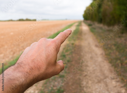 Doigt montrant chemin campagne