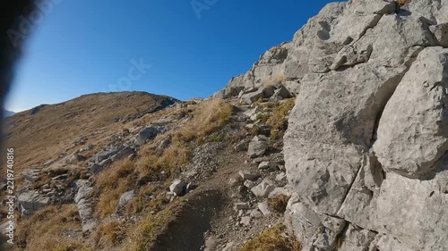 POV hiker walks with trekking poles across rugged terrain on the Czerwone Wierchy ridge
