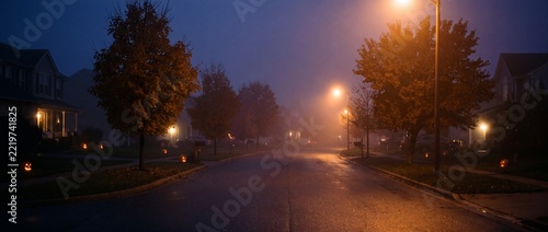 Suburban street at night with glowing jack o lanterns