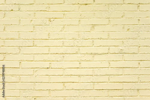 Pale yellow painted brick wall with clear brick and mortar texture
