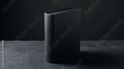 A professional minimalist book mockup featuring a sleek black hardcover standing upright on a dark textured stone surface background