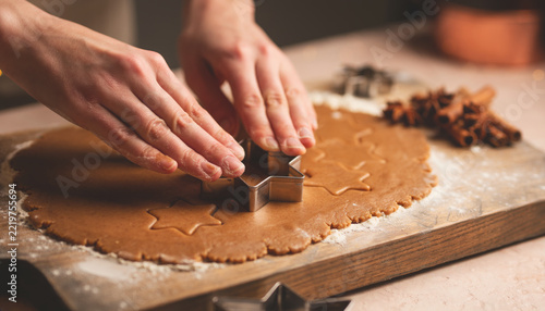 Hands cutting star-shaped cookies for the holidays