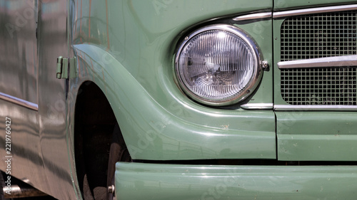Vintage green camper van close-up with headlight detail in Hoek van Holland, The Netherlands