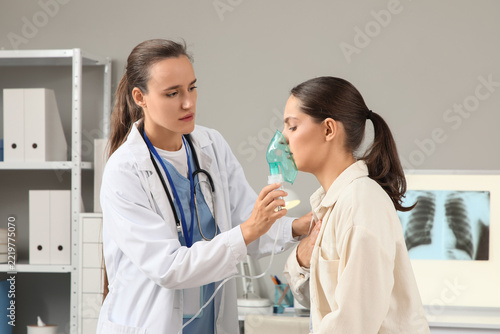 Respiratory therapy and asthma treatment, doctor helping patient with nebulizer mask for breathing support in medical clinic office