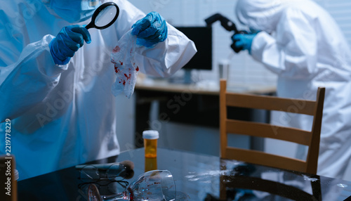 Forensic expert collecting a blood sample at a crime scene for laboratory analysis, DNA testing, criminal investigation, evidence examination, and justice.