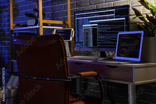 Software development and coding workspace, programmer desk with multiple scre...