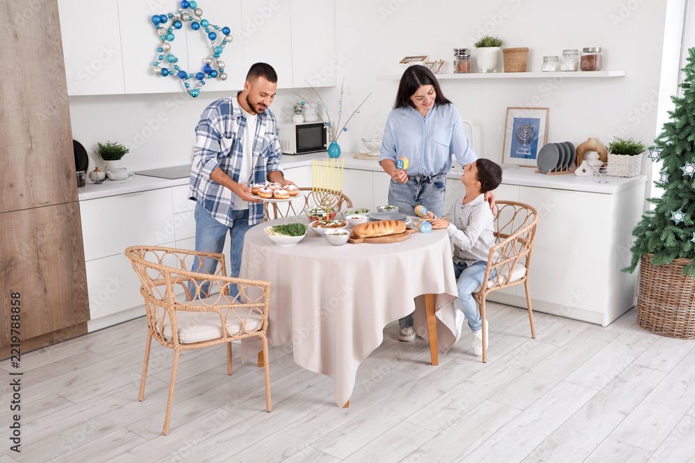 Fototapeta premium Hanukkah celebration and family traditions, parents and son preparing festive dinner with menorah and sufganiyot in a modern kitchen at home