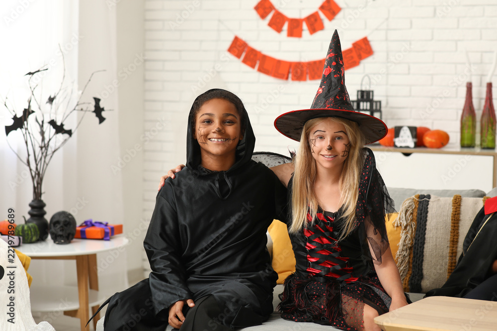 Fototapeta premium Halloween celebration, diverse children in costumes having fun at home party with festive decorations and face paint for trick or treat holiday event