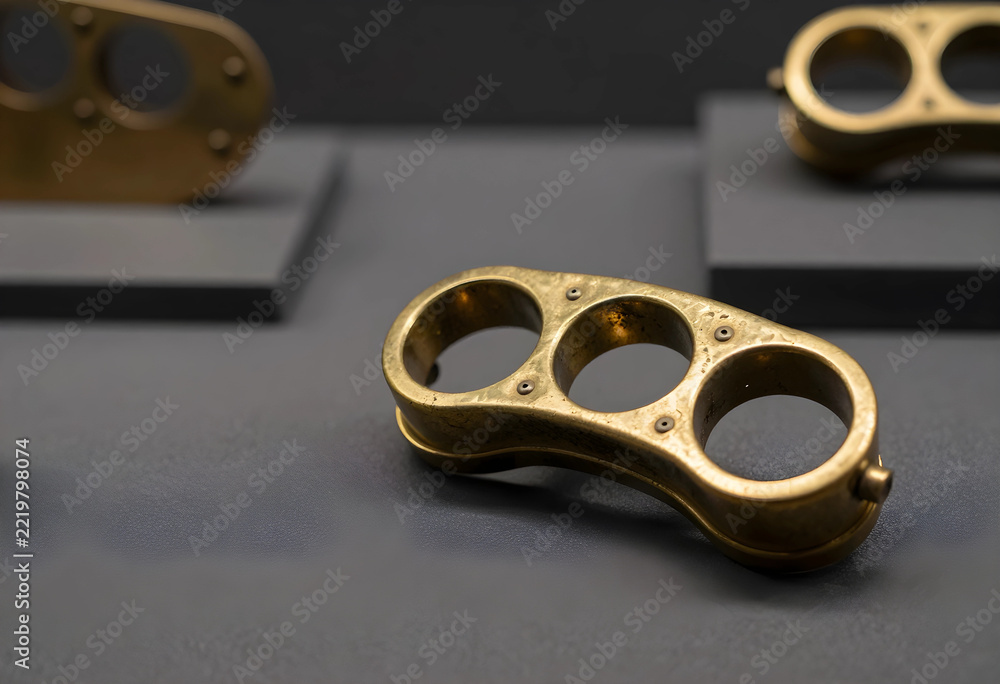 Fototapeta premium Violence and crime prevention, antique brass knuckle duster weapon on display in a museum exhibit for historical criminal justice and law enforcement