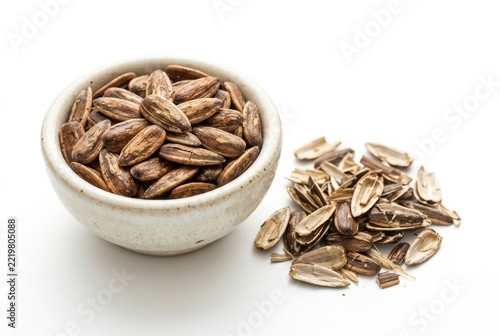 Roasted Sunflower Seeds in a Ceramic Bowl with Empty Shells on White Background - Healthy Snack Concept