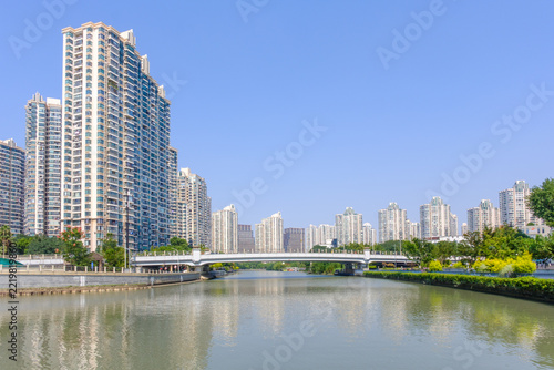 High rise residential buildings along an urban river with bridge