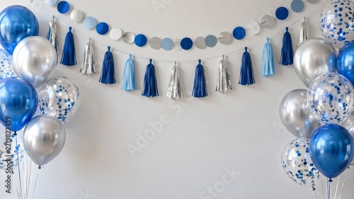 Blue Silver Balloons and Tassel Garlands Framing a Bright Empty Wall