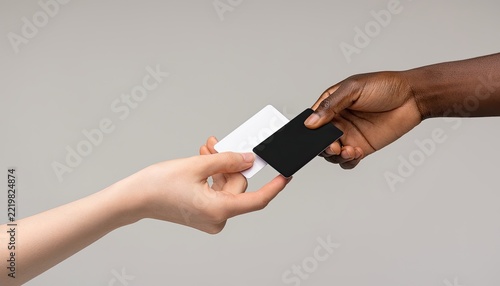 Two hands exchanging blank cards, one black and one white.