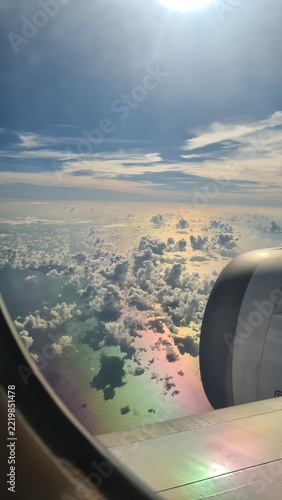 Photography View from an airplane window above clouds and sunlit ocean