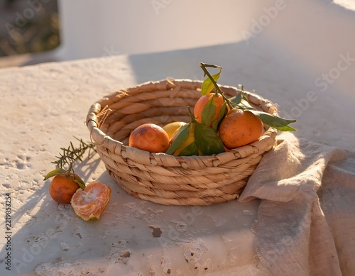 Simple Handwoven Natural Palm Fiber Basket Holding a Modest Assortment of Winter Citrus Fruits, Rustic Seasonal Still Life