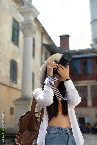 Young Female Tourist taking Photo with Professional DSLR Camera in European City
