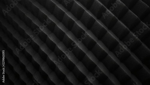 Dark charcoal wedged acoustic foam panel macro. Studio soundproofing.