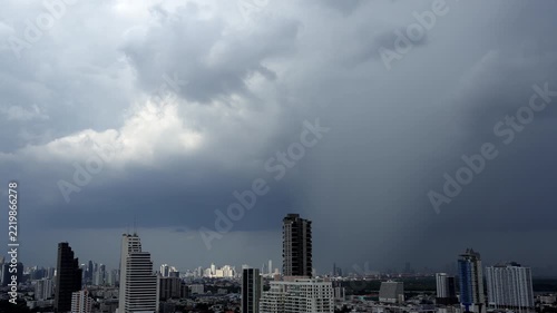 Time-lapse of Heavy rainfall pouring from towering thunderclouds above an urban landscape