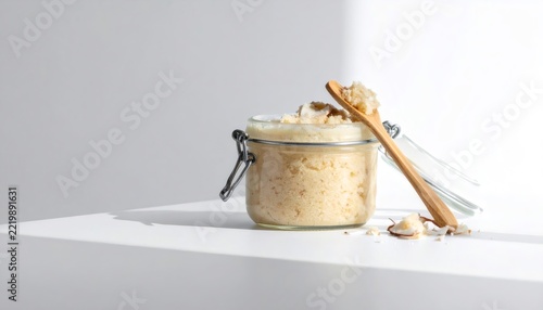 Coconut body scrub in jar with wooden spoon