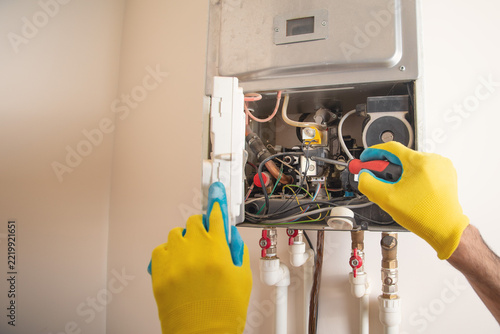 Master repairs a heating system in apartment.