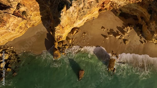 Drone top down view of Praia da Marinha beach in Algarve, Portugal, with ocean cliffs, sea stacks and limestone stacks and shore. Top down view shot.