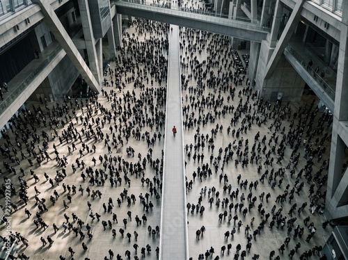 Large crowd walking through modern indoor event space with central