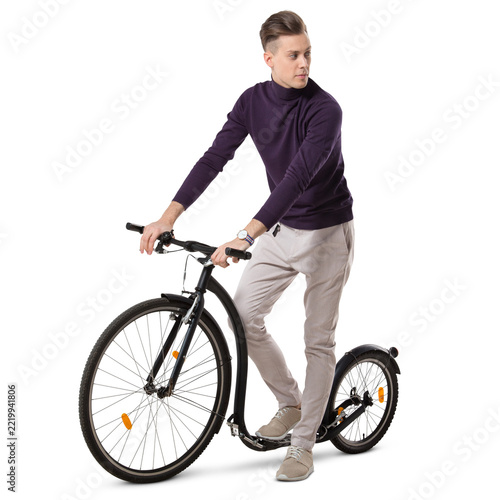 Young man riding a trendy big wheel scooter, isolated on white and transparent background.