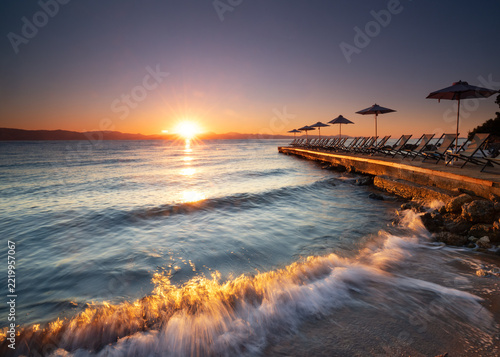 waves crashing on the beach in the morning in sunrise light in autumn