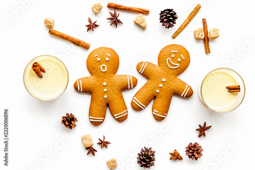Eggnog for christmas evening. Two glasses near gignerbread cookie on white background top view