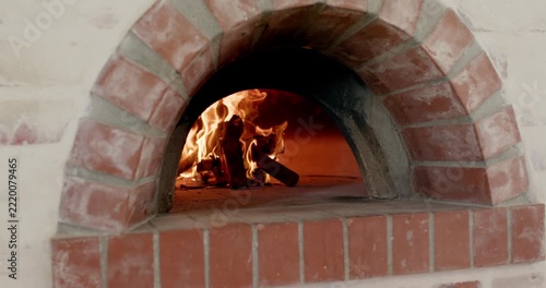 Sparking flames are consuming firewood and are growing to heat brick oven for baking